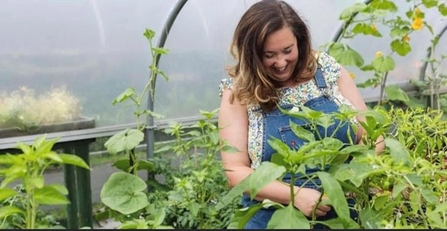 Photo of Victoria Holden, the Director of Northern Lily CIC, gardening in greenhouse.